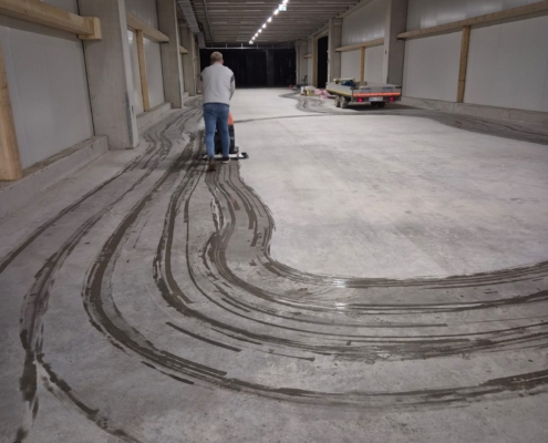 Mitarbeiter von Hausmeisterservice Sykora bei der maschinellen Grundreinigung eines Hallenbodens
