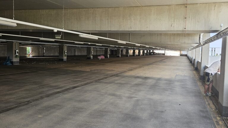 Parkdeck mit gereinigter Fahrfläche im vorderen Bereich