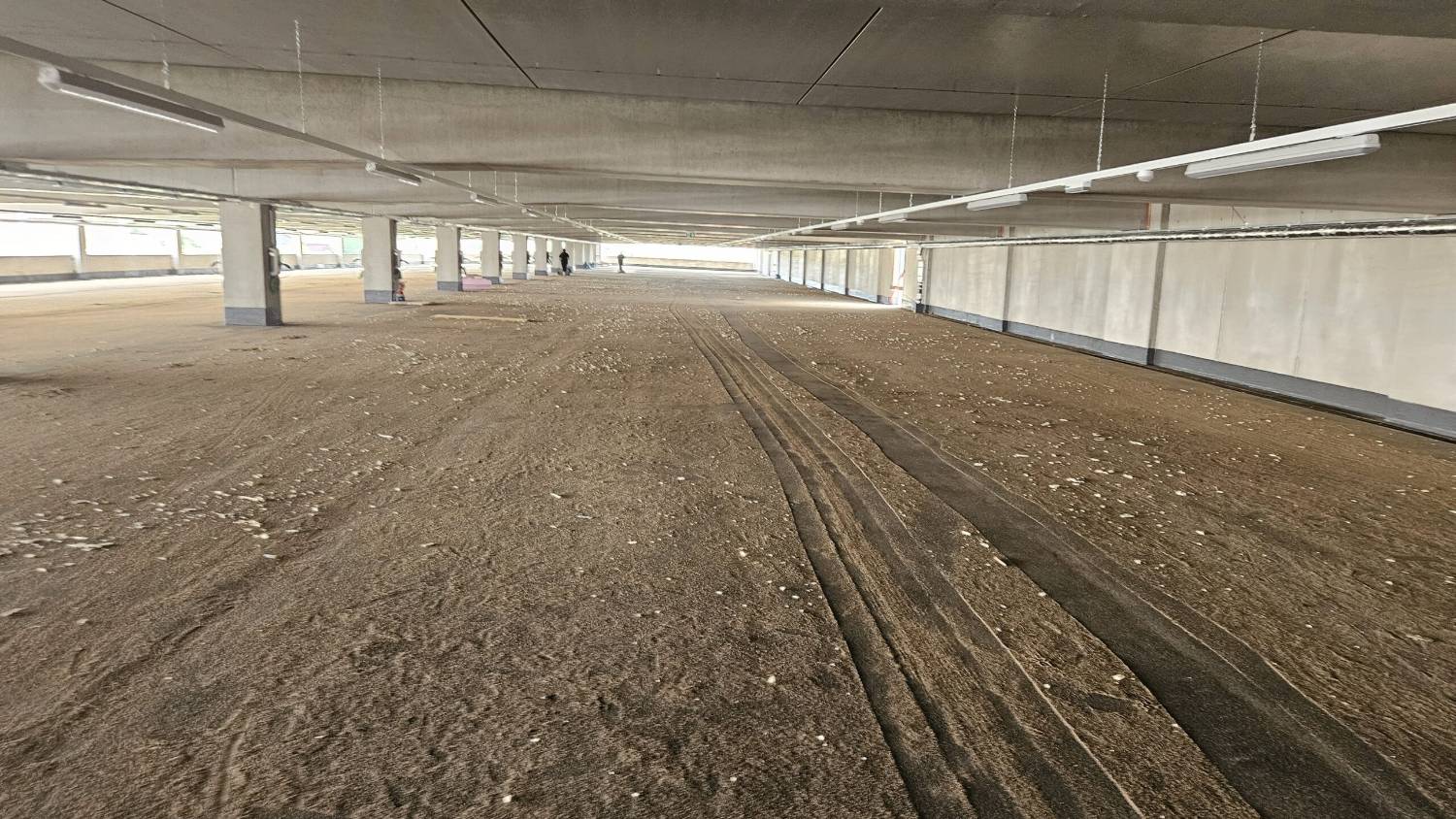 Noch ungereinigte Parkebene mit Staub und Reifenspuren