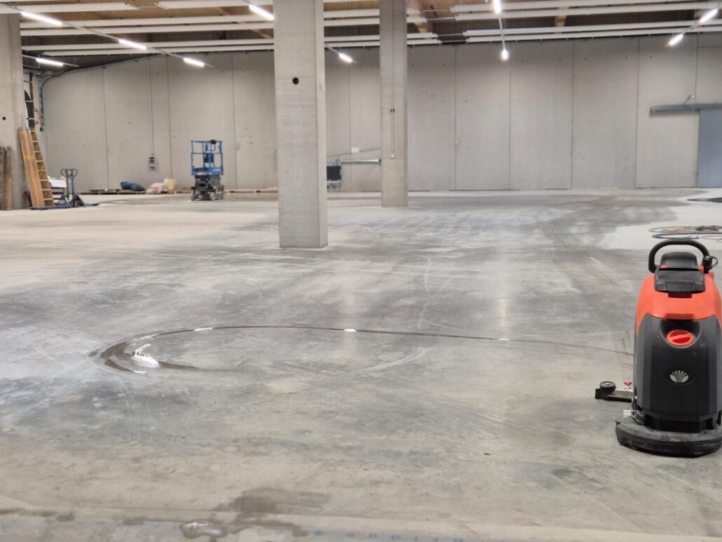 Scheuersaugmaschine auf einem Hallenboden nach dem Bau