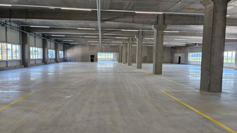Grosse Gewerbehalle mit Betonstützen und gereinigtem Boden