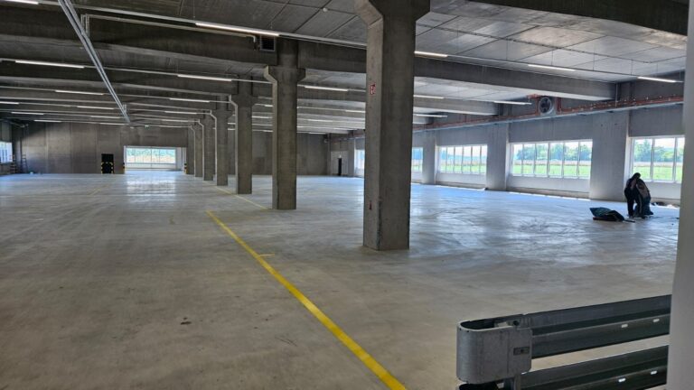 Gewerbehalle mit Betonstützen und frisch gereinigtem Boden