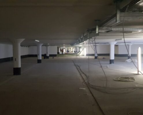 Tiefgarage im Rohbau mit Stützen und ausgelegten Kabeln