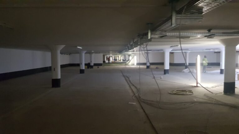 Tiefgarage im Rohbau mit weiß gestrichenen Stützen