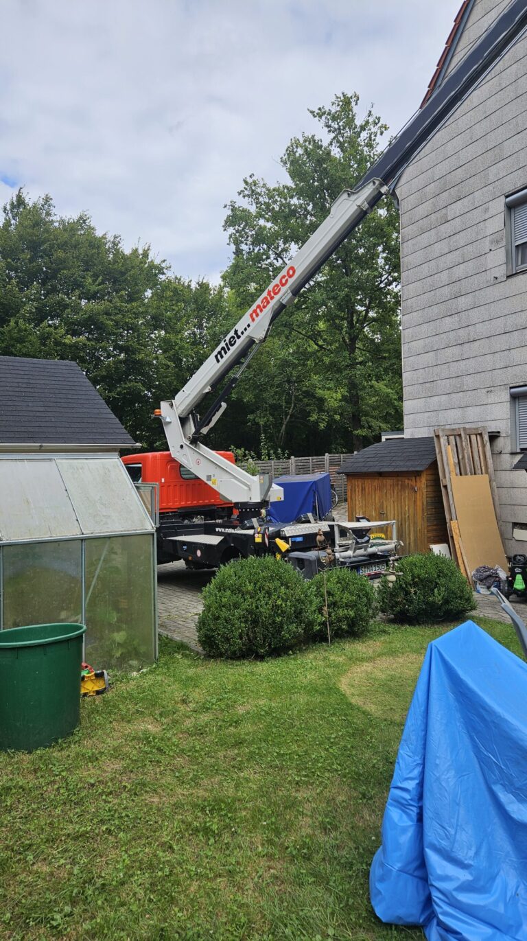 Hubarbeitsbühne für die Dachkontrolle im Garten neben dem Wohnhaus aufgestellt